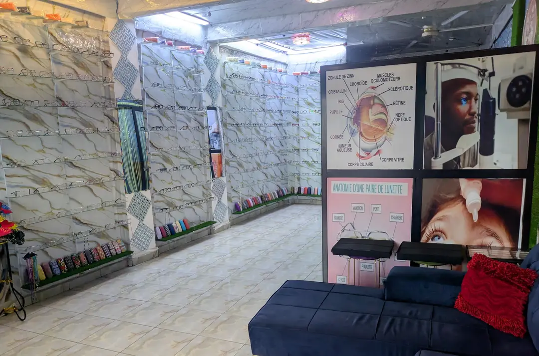 Inside the DM OPTIQUE SARL practice in Bonaberi, frame display walls and seating.